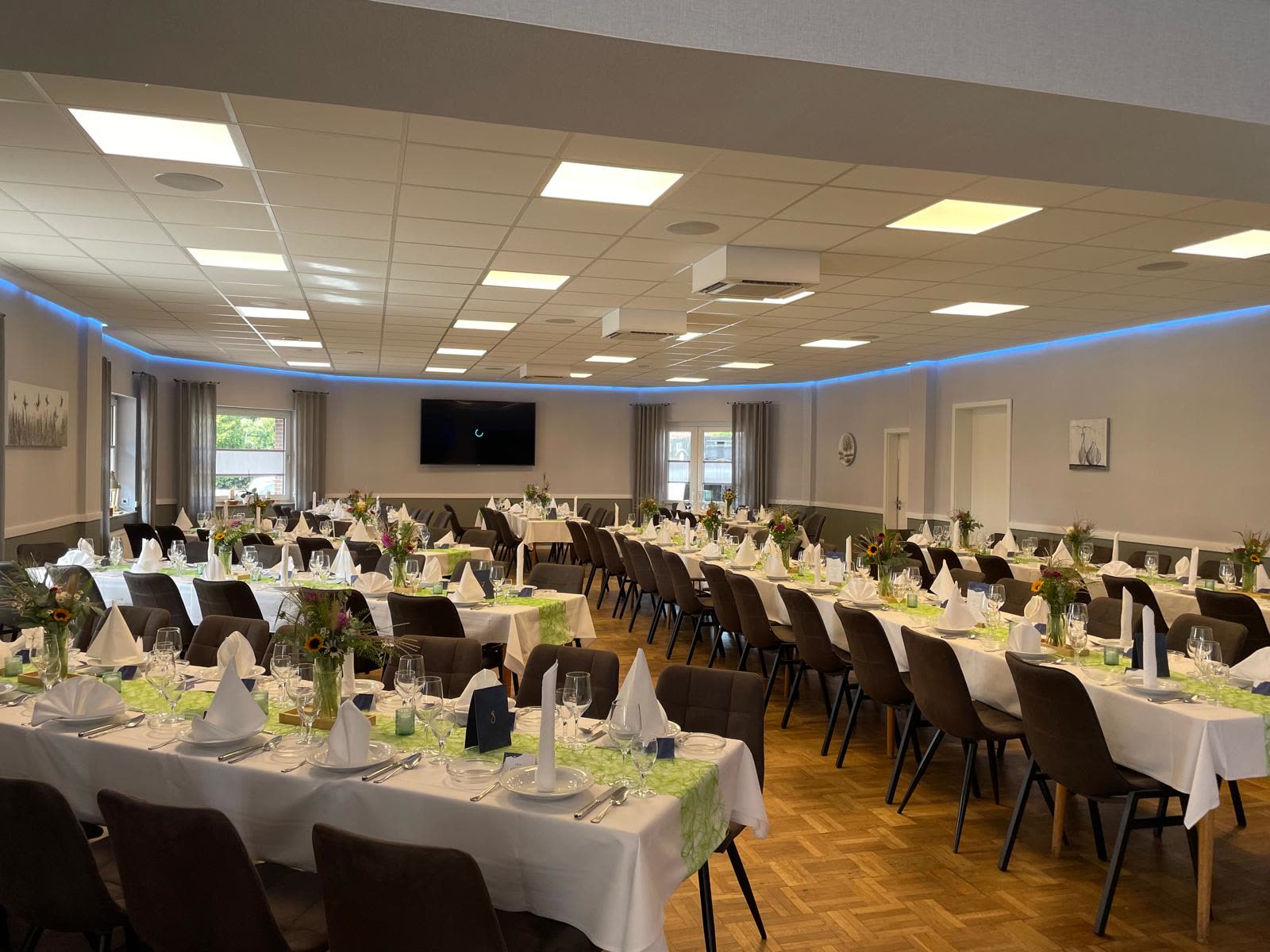 Festlich eingedeckter Saal mit langen Tafeln