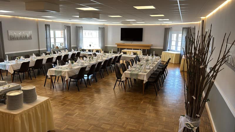 Heller Festsaal mit eingedeckten Tischen