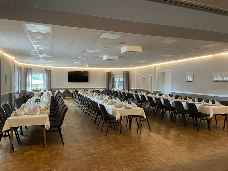Großer Festsaal mit langen Tafeln